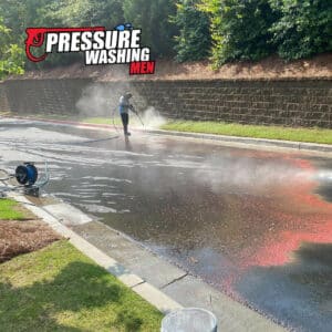 Pressure washing men team performing drive entrance cleaning in lawrenceville georgia