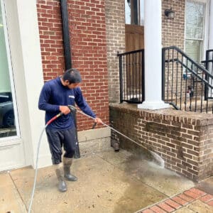 person cleaning brick wall with pressure washing method in johns creek georgia